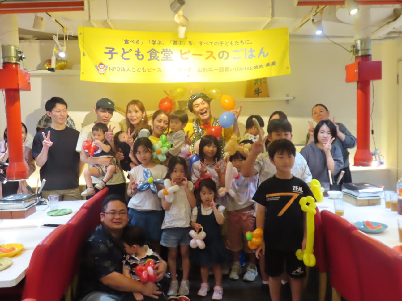 子ども食堂「ピースのごはん」で子供たちに囲まれて笑顔を見せる熊切あさ美（左）とハッピーつつい