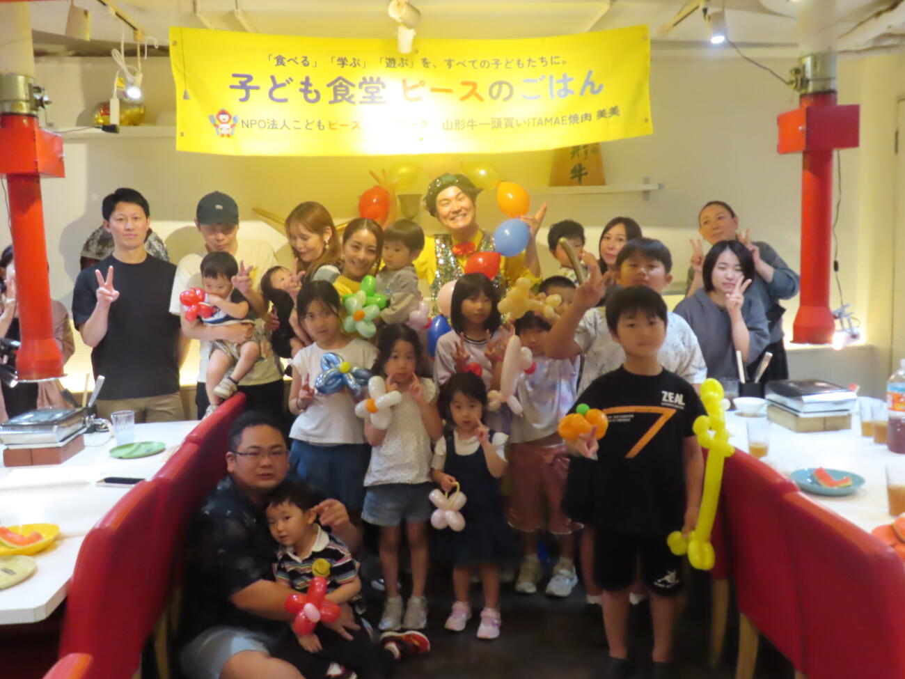 子ども食堂「ピースのごはん」で子供たちに囲まれて笑顔を見せる熊切あさ美（左）とハッピーつつい