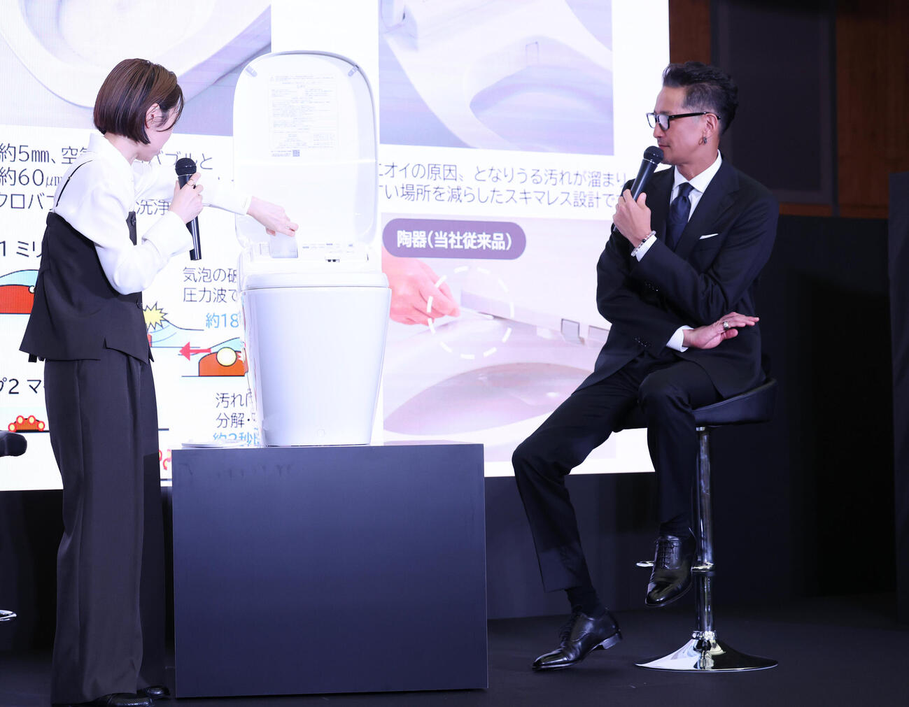 新製品発表会に登壇し、トイレ企画部商品企画課福永奈央課長（左）の説明を聞く松岡昌宏（撮影・増田悦実）