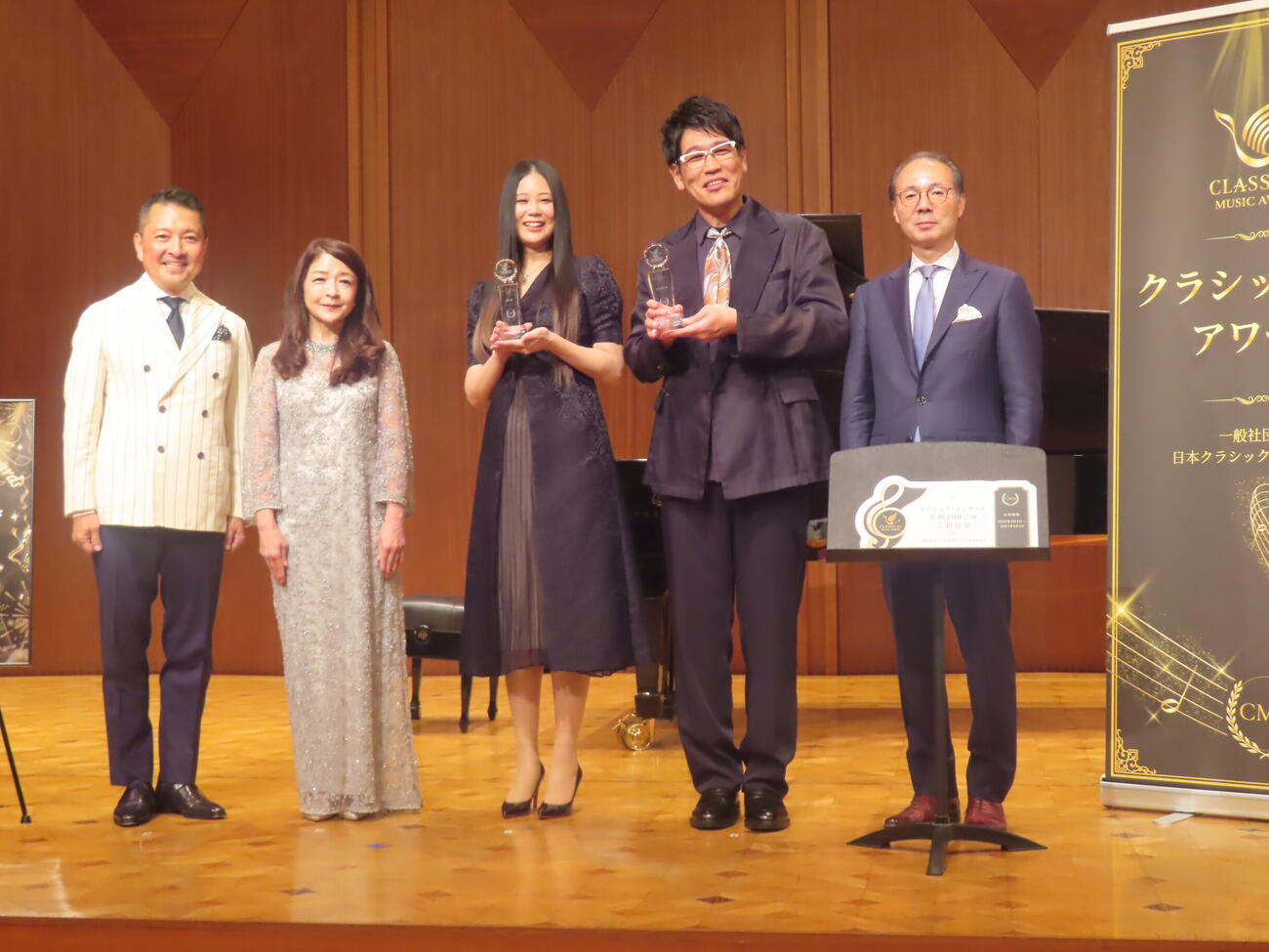 「第1回　クラシック音楽アワード　2026」の授章式に出席した、左から司会の朝岡聡、プレゼンターを務めたピアニスト仲道郁代、naco、古坂大魔王、日本クラシック音楽事業協会の入山功一会長