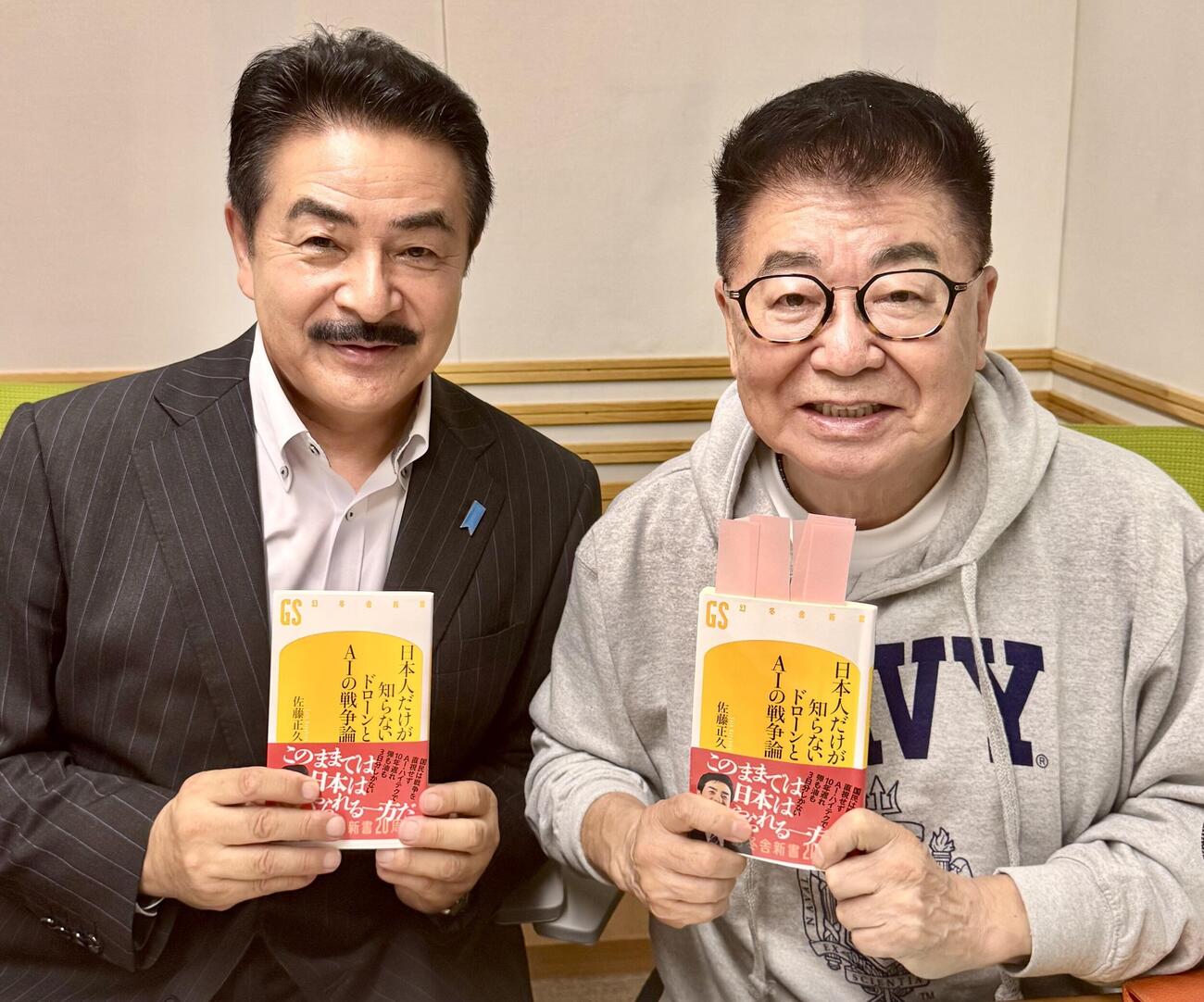 佐藤正久氏（左）の新刊「日本人だけが知らないドローンとAIの戦争論」（幻冬舎新書）を一緒に手にする生島ヒロシ