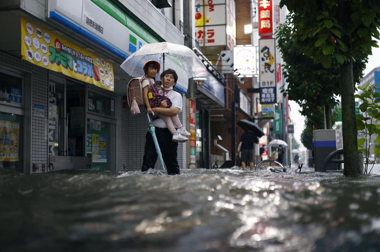 大雨で水があふれた名古屋市瑞穂区の市街地を歩く人たち（共同）