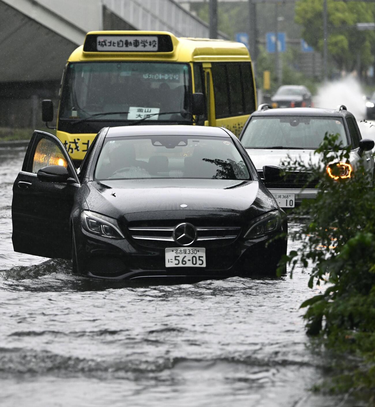 大雨で道路に水があふれ、動けなくなった車両（共同）
