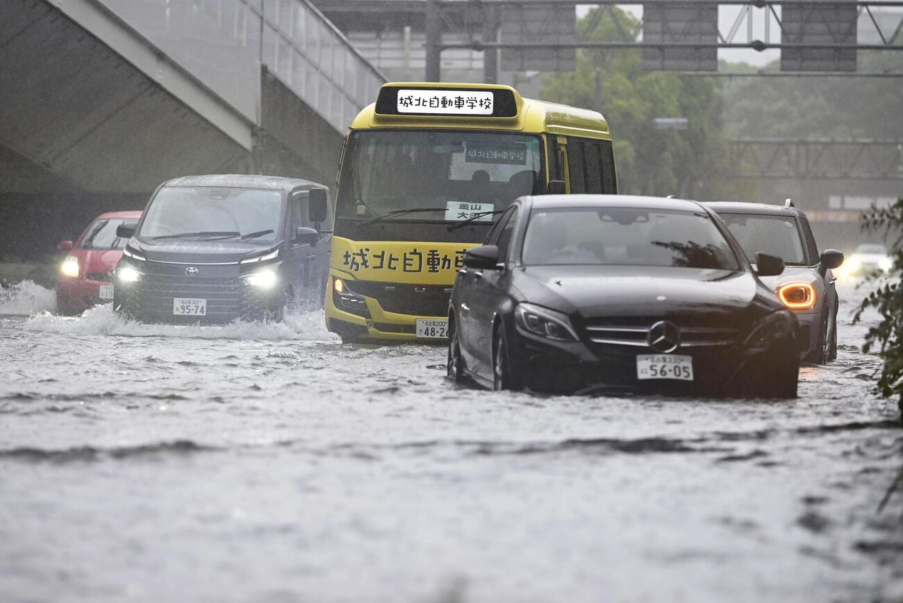 大雨で水があふれた名古屋市中区の道路。複数の車両が動けなくなっていた（共同）
