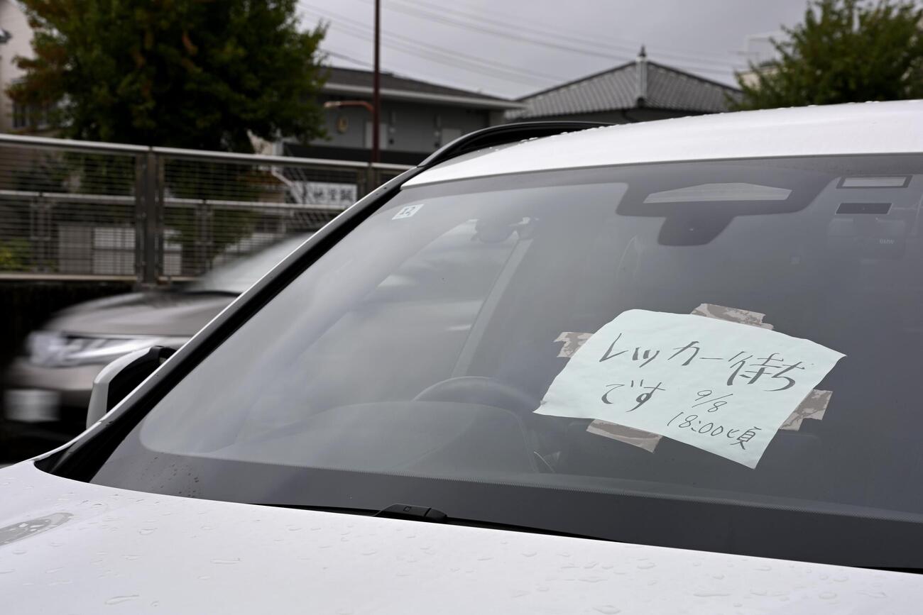 フロントガラスに紙が張られた、大雨で被災し路上に残された車両（共同）