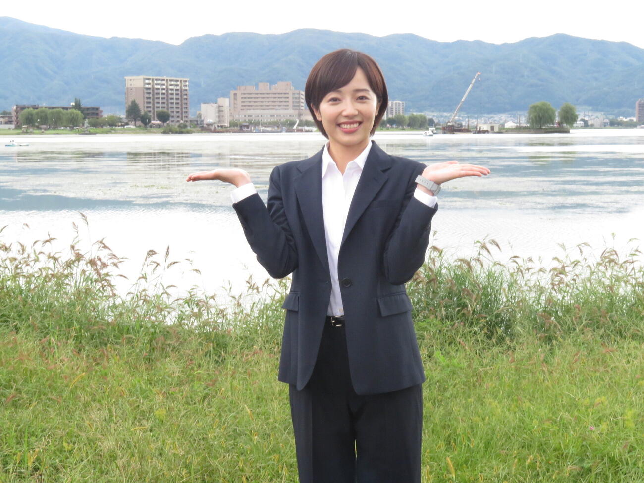 クランクインした「巡るスワン」のロケ地、長野・諏訪市の諏訪湖をバックにスーツ姿で笑顔を見せる森田望智