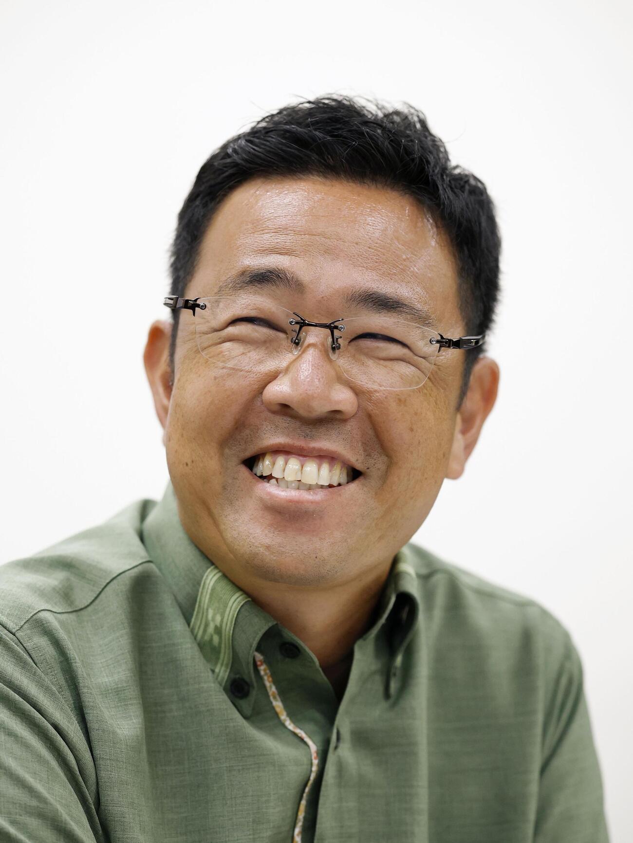 沖縄県知事選から一夜明け、笑顔で報道陣の取材に応じる古謝玄太氏＝14日午前、那覇市（共同）