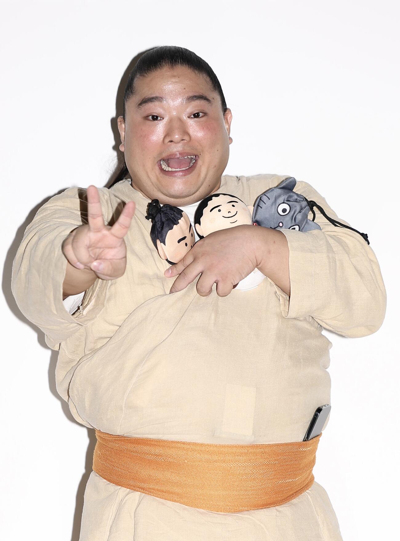 ポーズを決め写真に納まる富栄ドラム（撮影・河田真司）