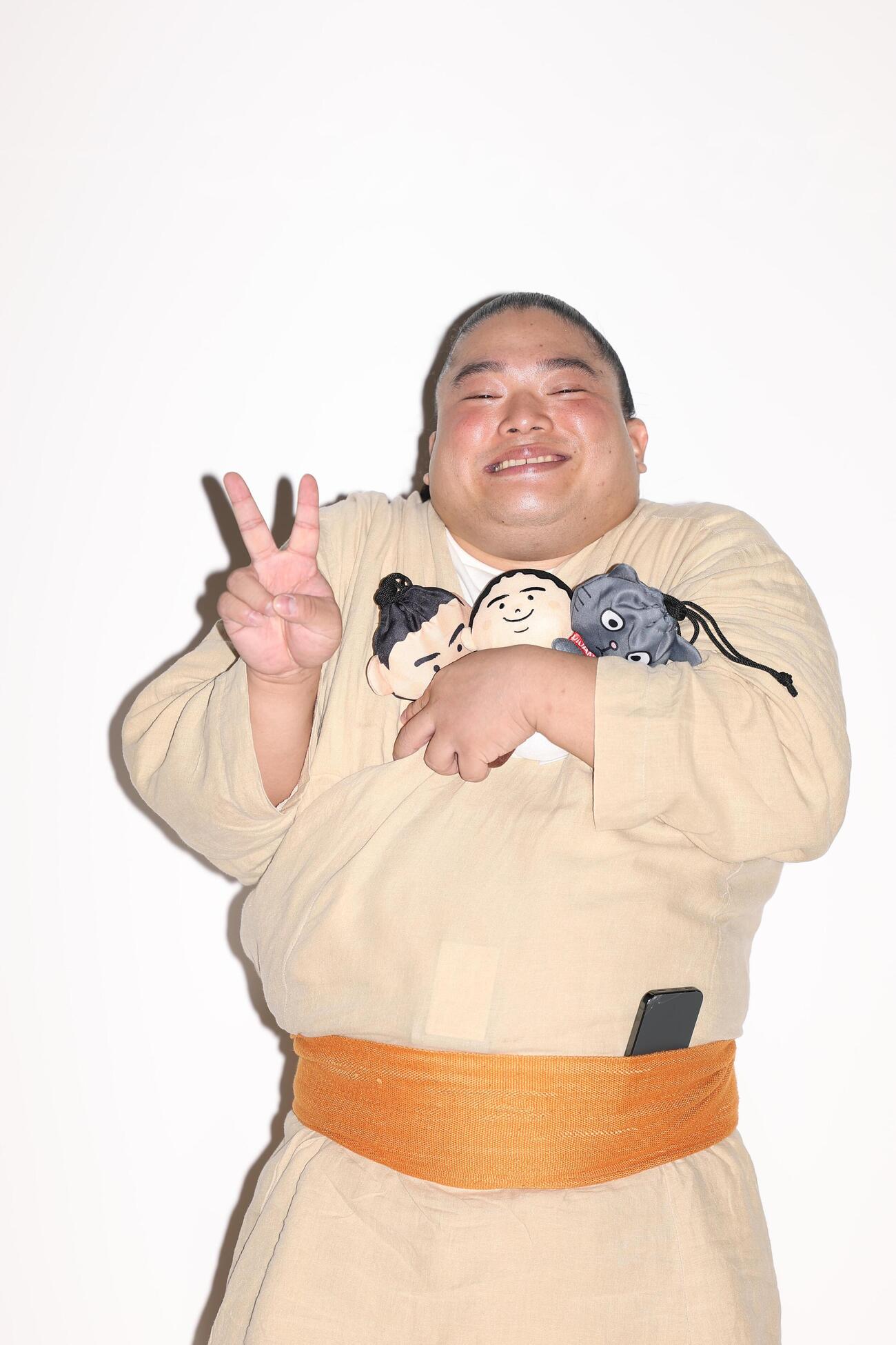 ポーズを決め写真に納まる富栄ドラム（撮影・河田真司）