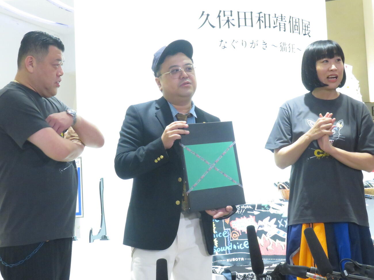 「久保田和靖」として個展を開催したとろサーモン久保田（中央）が、6660万円で販売する絵を説明し、くっきー！（左）としずちゃんも驚きの表情