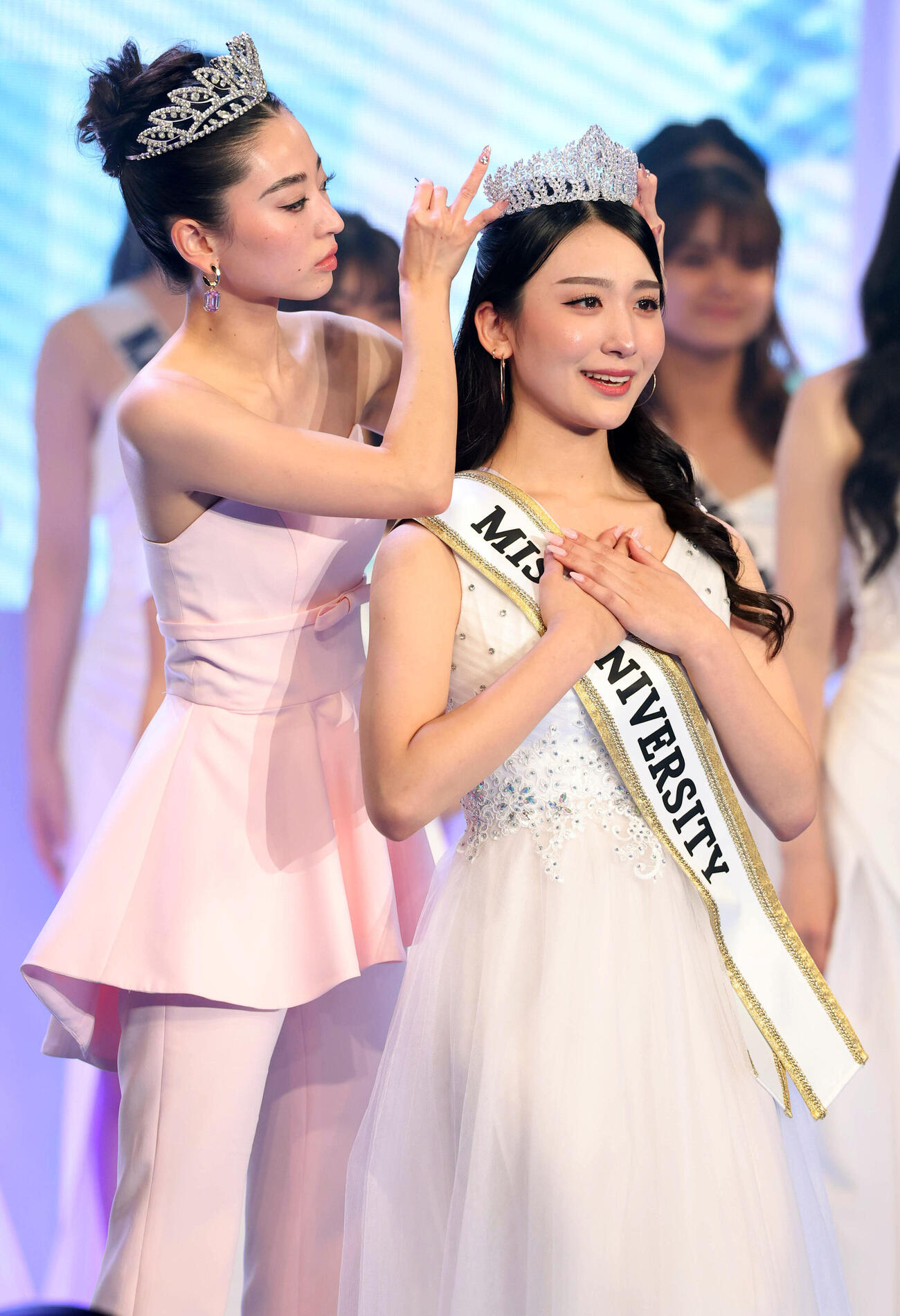 ミスユニバーシティ2026でグランプリに輝いた東京代表の熊丸うた子さん（手前）は飯田樺楽さんからティアラをかぶせてもらう（撮影・浅見桂子）