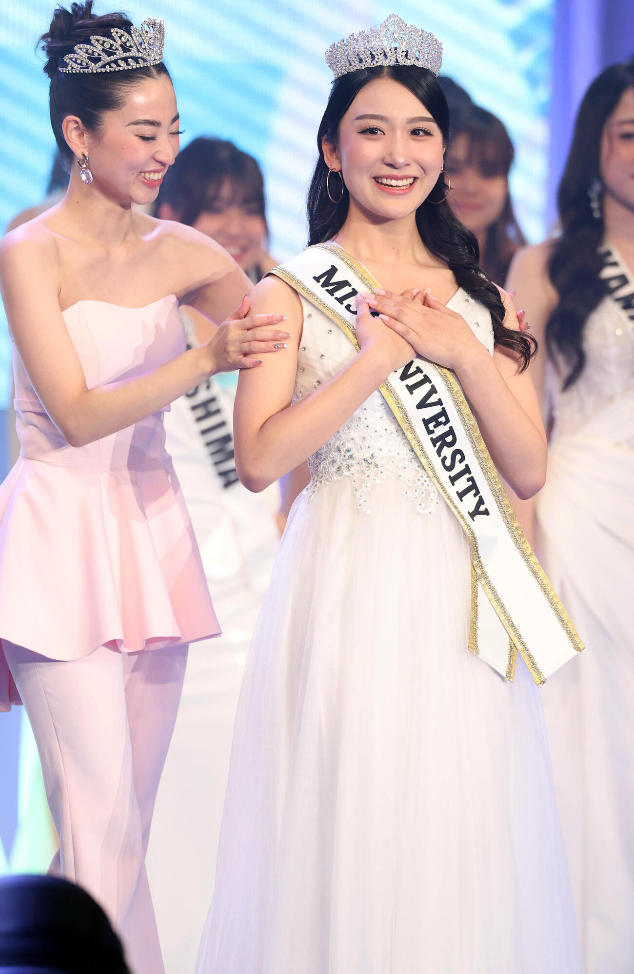 ミスユニバーシティ2026でグランプリに輝いた東京代表の熊丸うた子さん（右）は飯田樺楽さんからティアラをかぶせてもらい笑顔（撮影・浅見桂子）