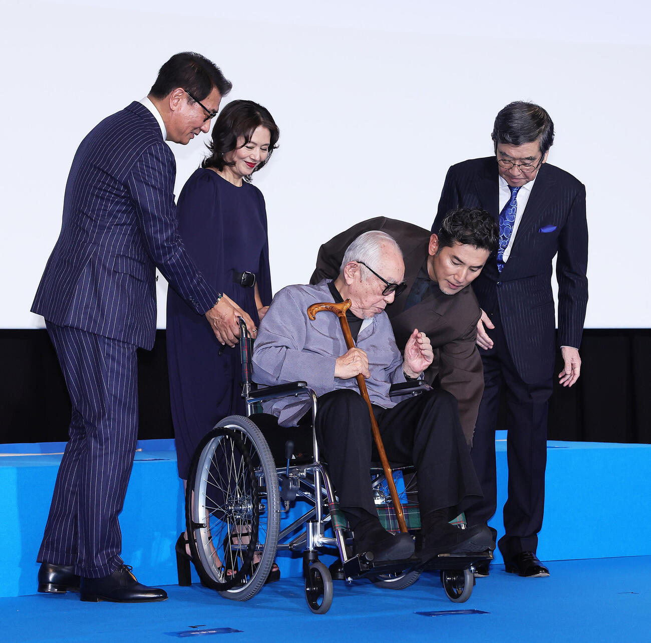 映画「海の沈黙」舞台あいさつを終え、原案・脚本の倉本聰氏（中央）の車いすを補助する、左から中井貴一、小泉今日子、1人おいて本木雅弘、石坂浩二（24年10月31日撮影）