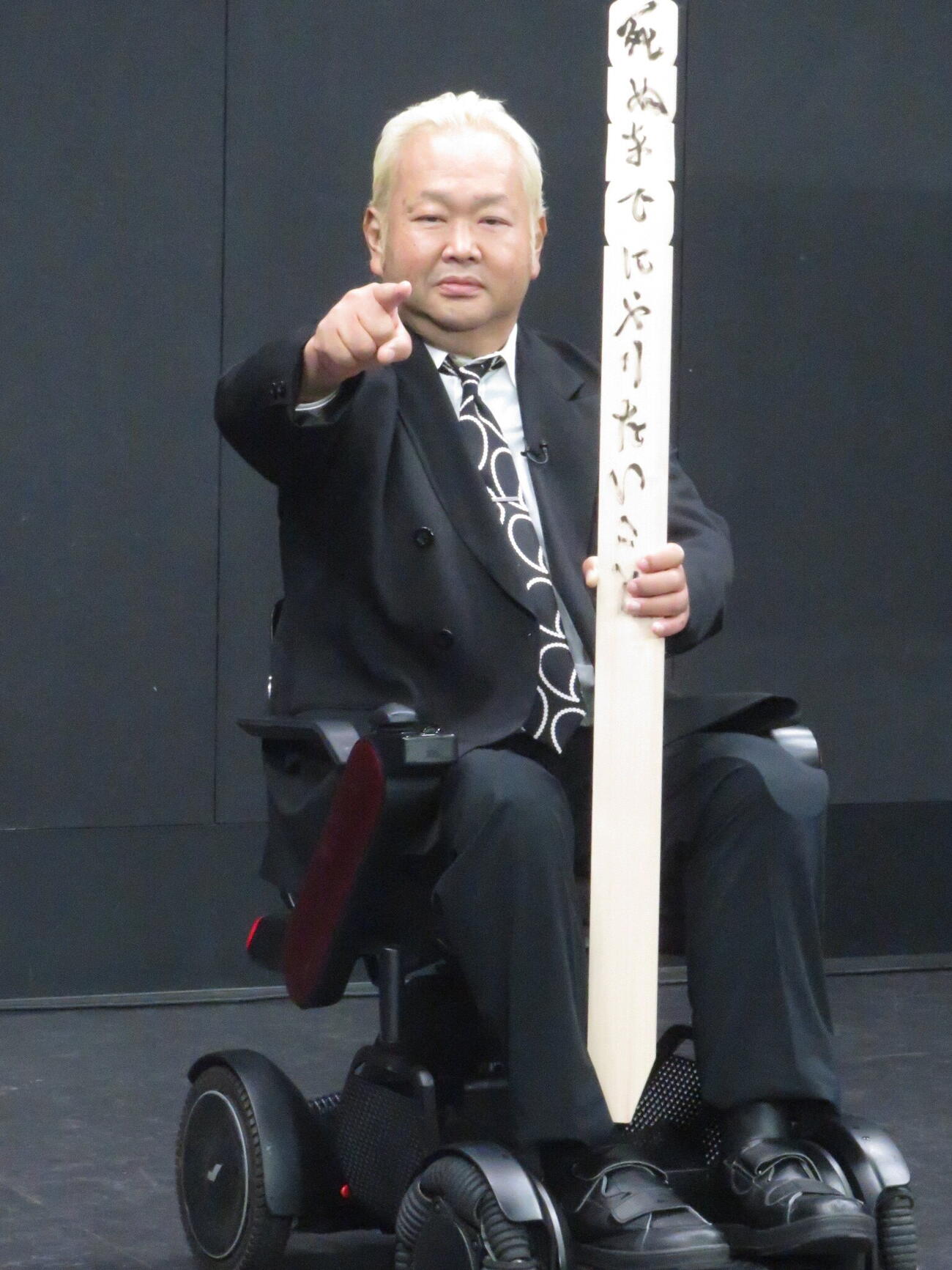卒塔婆に「死ぬまでにやりたいこと」と番組名を書き、かつて対戦した大仁田厚の「ファイヤー」のポーズをつくるハチミツ二郎