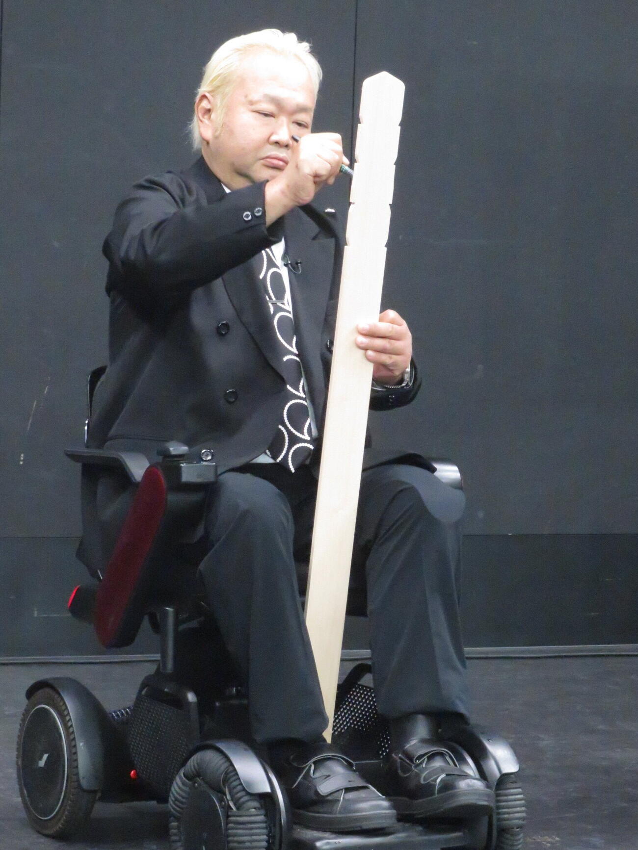 卒塔婆に発表する番組名を書くハチミツ二郎