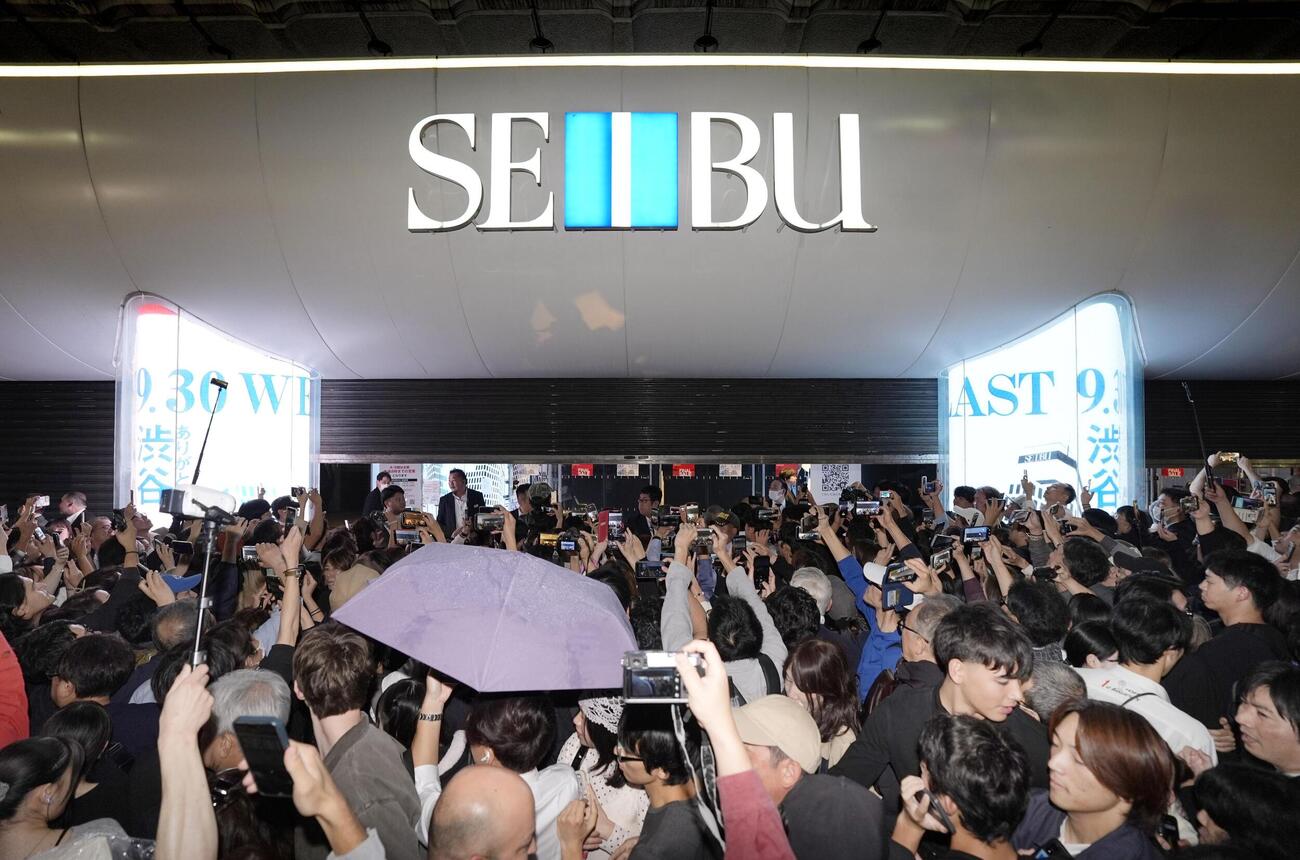 大勢の人が見守る中、シャッターが下ろされる西武渋谷（9月30日夜、共同）