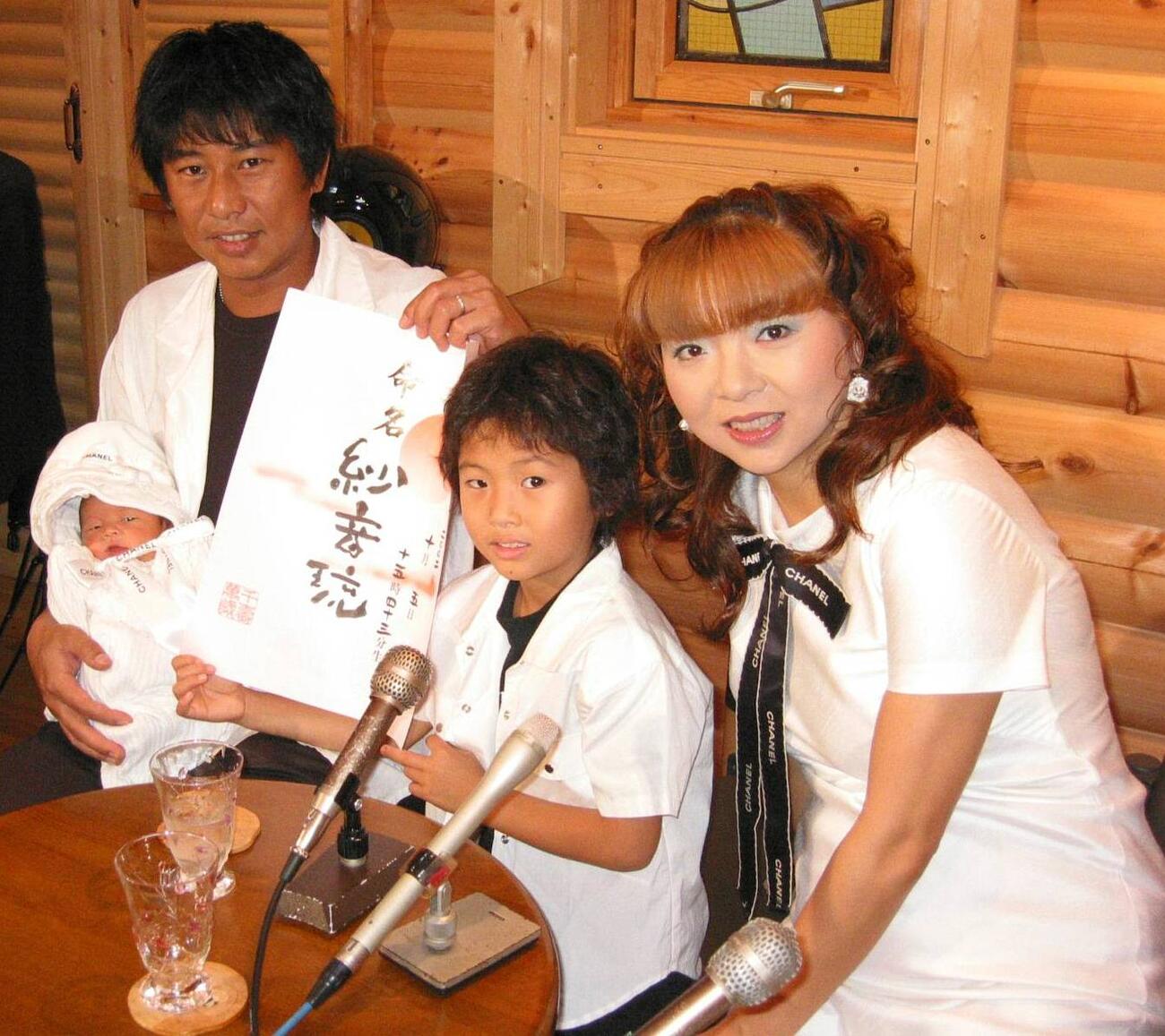 2002年10月、第3子の女児を出産し会見したハイヒール・モモコ（右端）と夫の政仁さん（左端）、長男の仁一郎くん