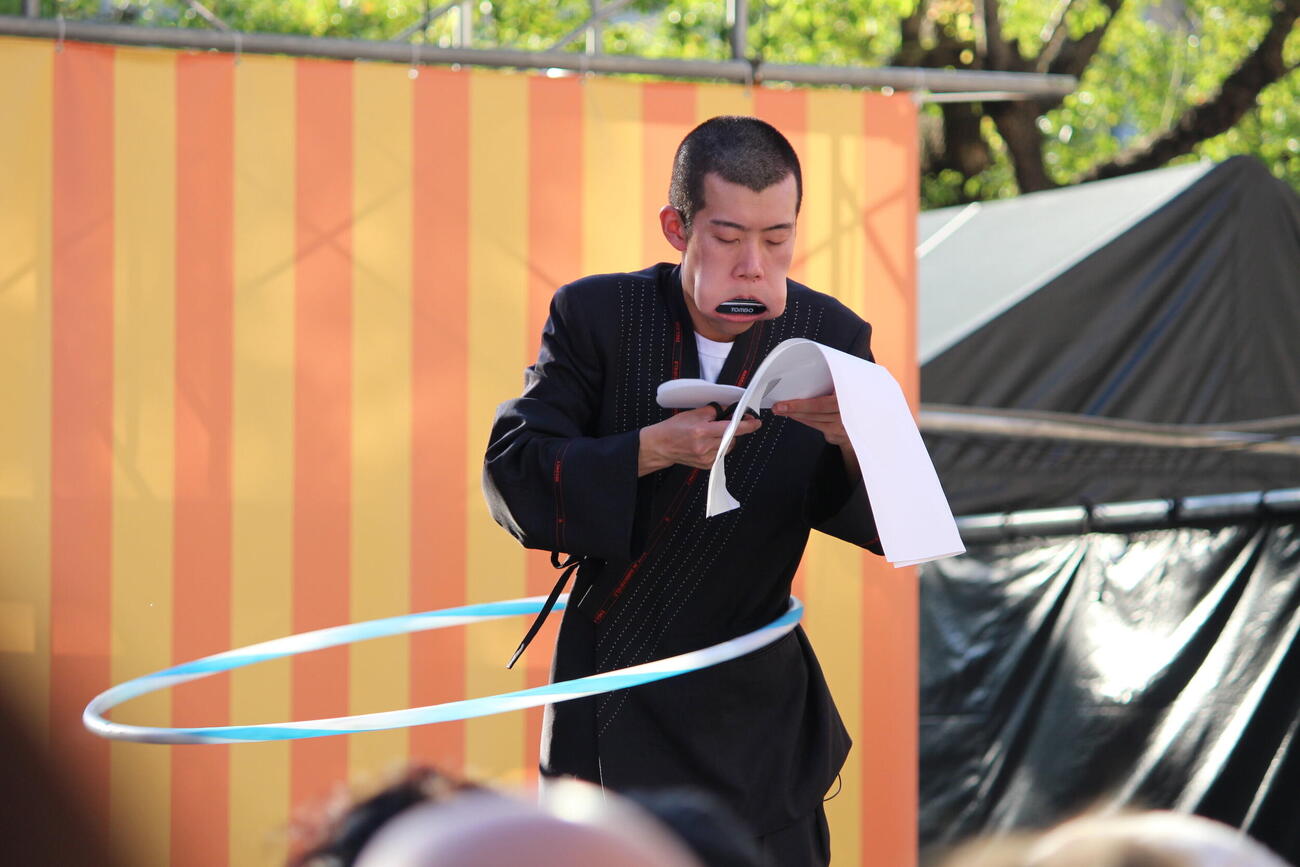 口にハーモニカ、腰にフラフープ、手で紙切りのトリプルプレー。「OSAKA COMEDY FESTIVAL 2026」で妙技を披露した清川雄司