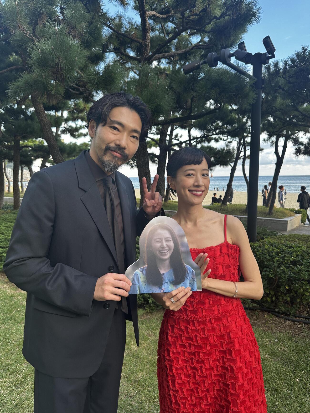 「このごにおよんで愛など」で釜山国際映画祭に参加した柄本佑（左）、石橋静河は欠席した長澤まさみの顔パネルを手にする