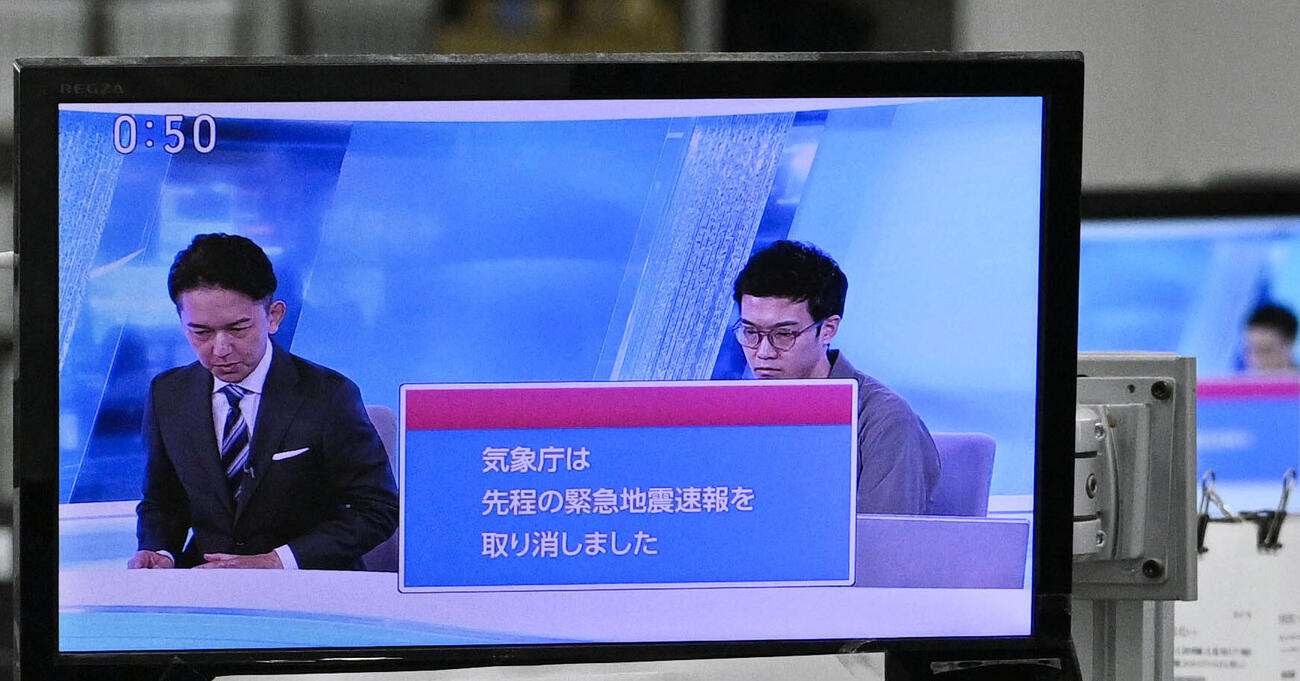 緊急地震速報の取り消しを報じるテレビ画面＝16日午後0時50分、東京・東新橋（共同）