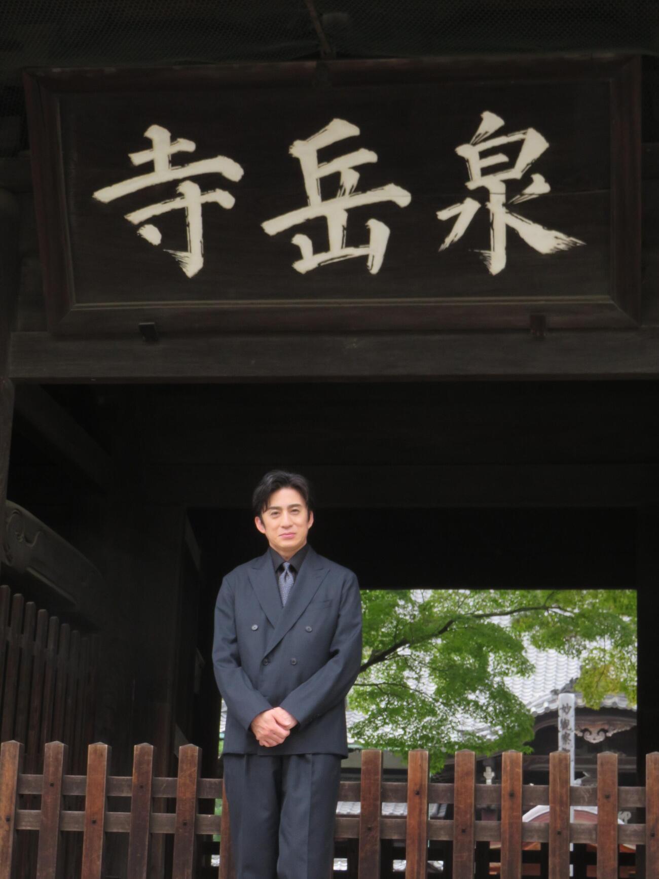 泉岳寺の山門前に立つ松本幸四郎（撮影・松本久）