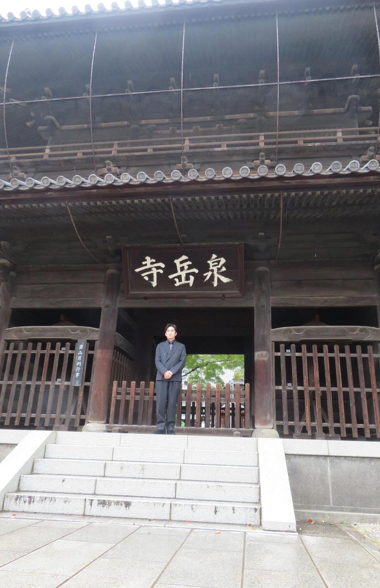 泉岳寺の山門前に立つ松本幸四郎（撮影・松本久）