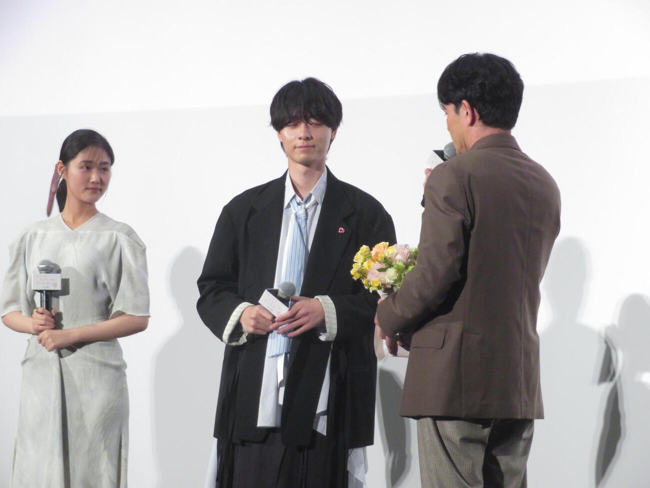 映画「ないものねだりの君に光の花束を」完成披露試写会にで吉沢悠（右）から花束を受け取る作間龍斗　