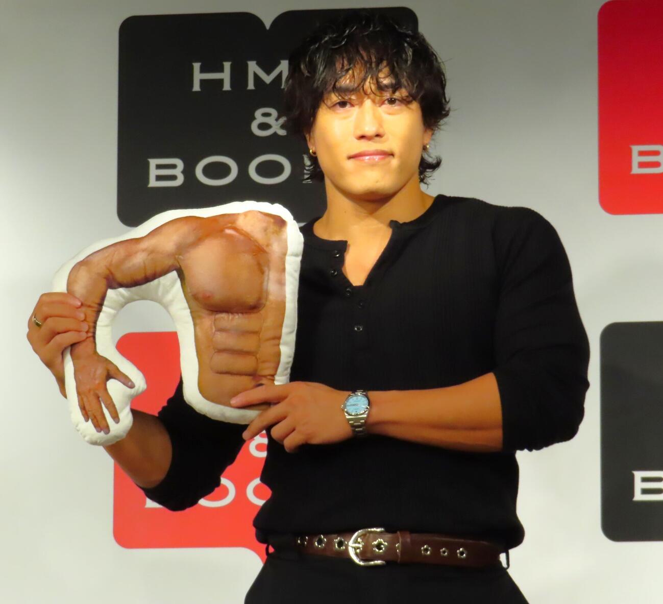筋肉クッションを手にする中務裕太