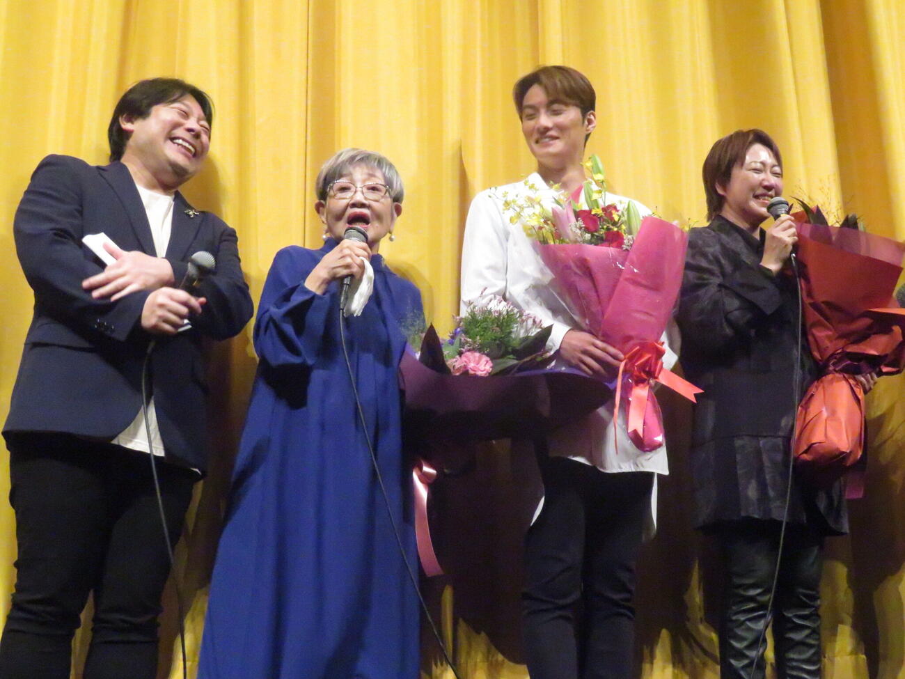 映画「AYUMI」の舞台あいさつで花束を受け取り、記念撮影中もマイクを手に話し続けた泉ピン子（左から2人目）。左端は寺西一浩監督、左から3人目は共演の寺西優真、右端は物語のモデルとなった増田あゆみさん
