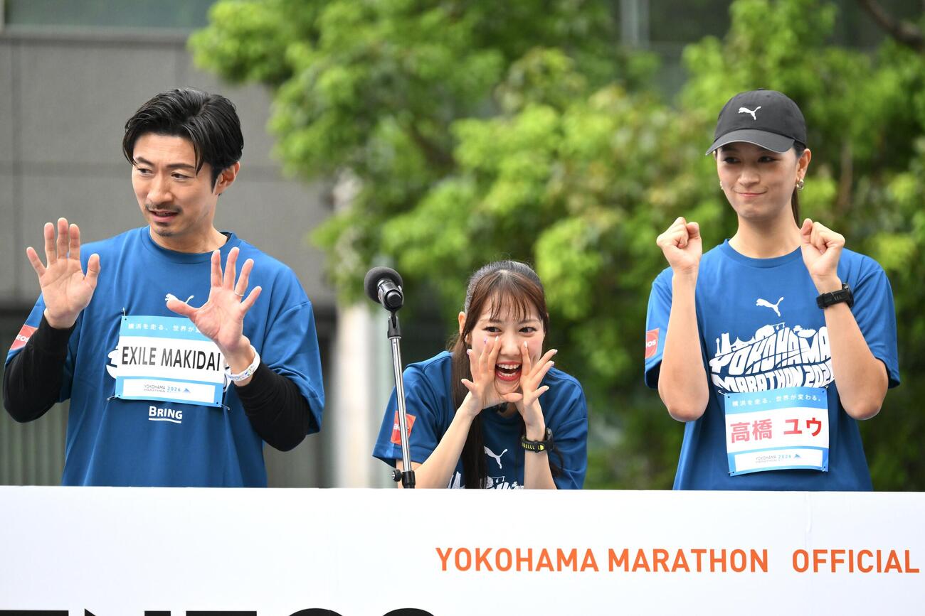 横浜マラソン2026でスタートしたランナーを声援する高城れに（中央）。左はEXILEのMAKIDAIと高橋ユウ（撮影・滝沢徹郎）