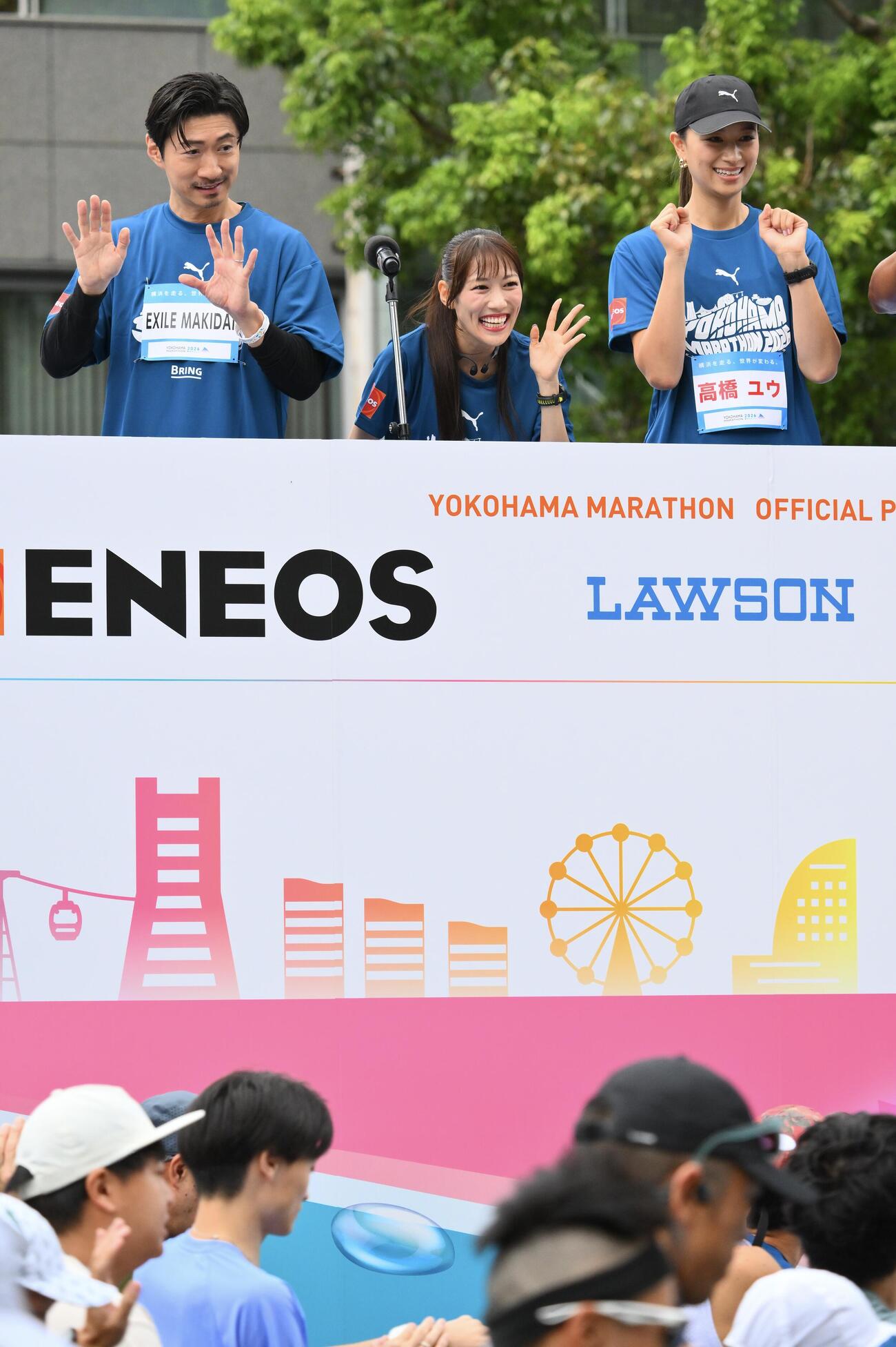 横浜マラソン2026でスタートしたランナーを声援する高城れに（中央）。左はEXILEのMAKIDAIと高橋ユウ（撮影・滝沢徹郎）