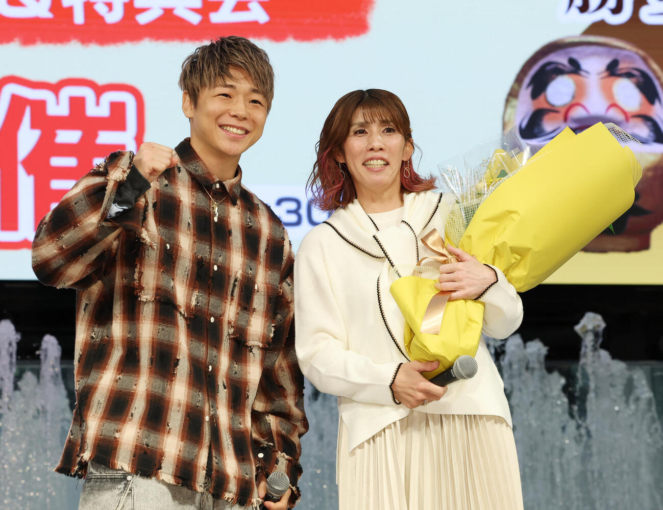 デビューシングル発売記念イベントにサプライズで登場した武尊（左）から花束を受け取った吉田沙保里（撮影・宮地輝）