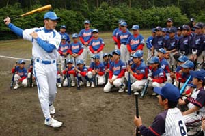 子供たちにバッティングフォームの見本を見せる高木大成講師
