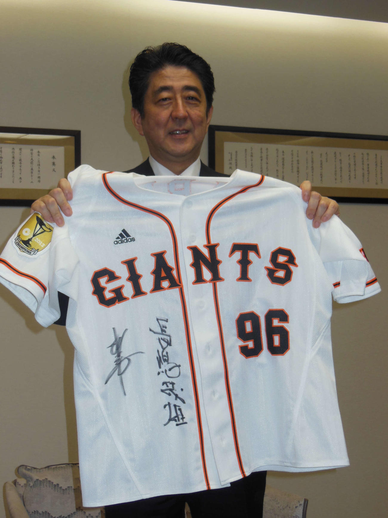 国民栄誉賞授与セレモニー後、長嶋、松井両氏がサインをした「96」のユニホームを披露した時の安倍晋三元首相（2013年5月5日撮影）
