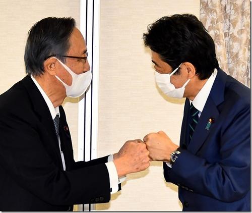 衆院議長就任が決まった細田博之氏（左）から清和会を受け継ぐことになり、派閥の会合で細田氏とグータッチする安倍晋三元首相（21年11月11日）