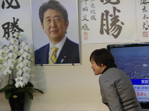 吉田真次氏の事務所に掲げられた安倍晋三元首相の遺影の前を横切る安倍昭恵さん（2023年4月23日撮影）