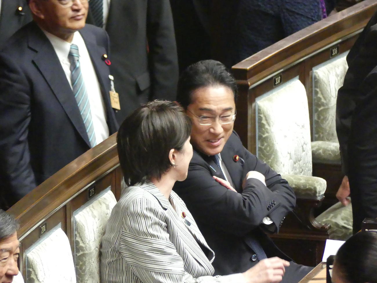 臨時国会が召集された10月20日、衆院本会議場の自席で高市早苗経済安保相（手前）と腕組みをしながら話す岸田文雄首相（2023年10月20日撮影）