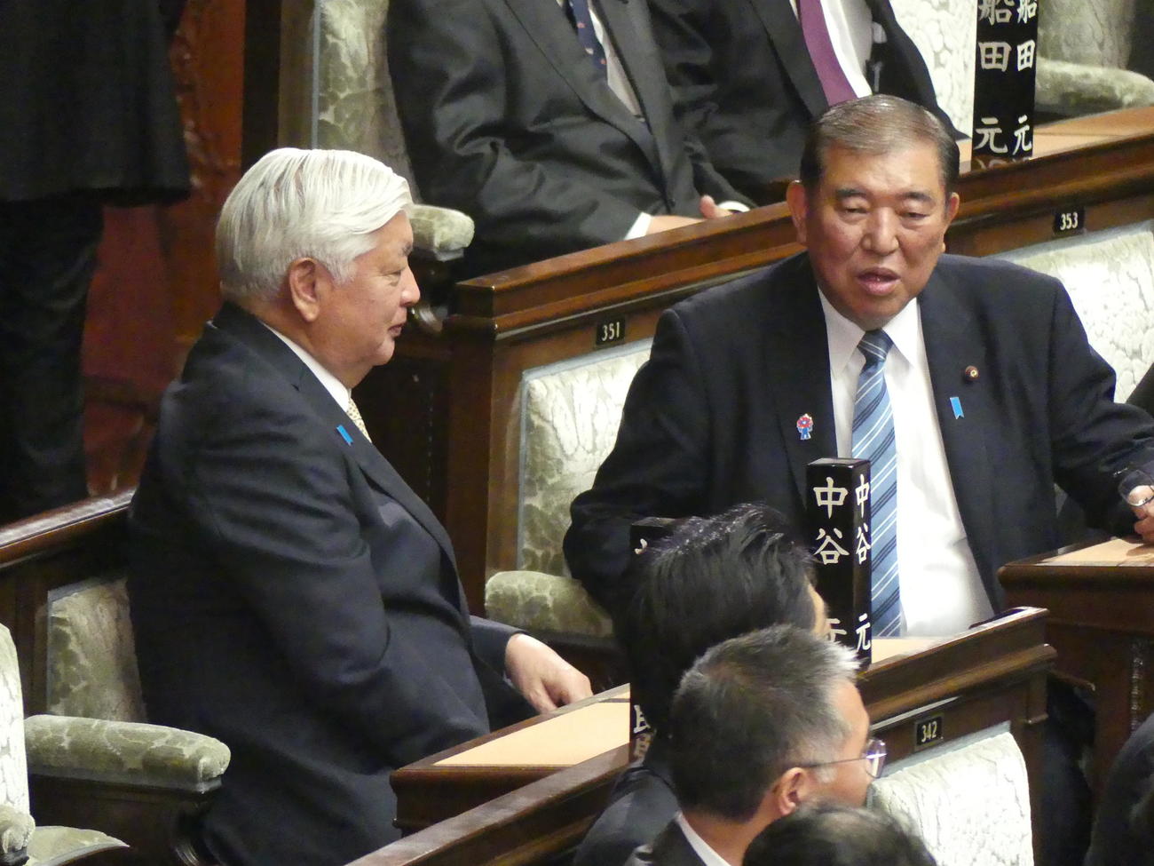 通常国会召集日、本会議場の自席で中谷元防衛相（左）と談笑する石破茂首相（2025年1月24日撮影）
