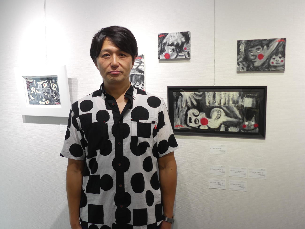 東京・銀座で開催中の個展で、石破首相を描いた風刺画「シゲルニカ」の前に立つ「ザ・ニュースペーパー」の福本ヒデ