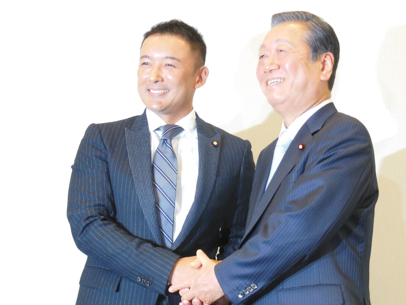「生活の党と山本太郎となかまたち」共同代表に就任し、握手を交わす山本太郎氏（左）と小沢一郎氏（2015年1月撮影）

