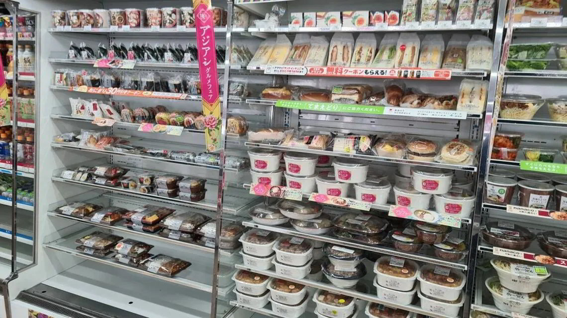 コンビニの弁当コーナー。おにぎりなどが置かれる左の常温ケースと右の冷蔵ケースでは管理温度が異なるが、近年は冷蔵ケース用の弁当が急拡大している（記者撮影）