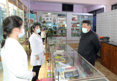 15日、薬局を視察する北朝鮮の金正恩朝鮮労働党総書記（右）（朝鮮中央通信＝共同）