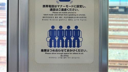 席を詰めて座るよう呼びかける電車内のステッカー（編集部撮影）