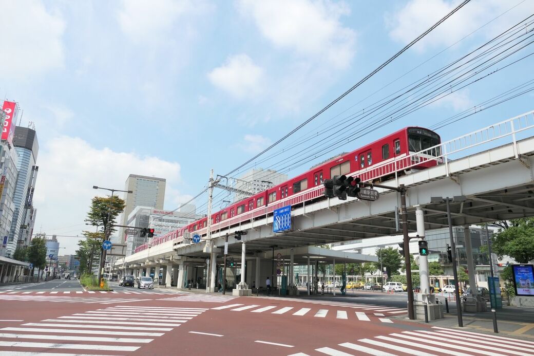 京急川崎駅を出発し横浜方面（画面奥）へ向かう電車。周辺には商業施設が集積している（記者撮影）