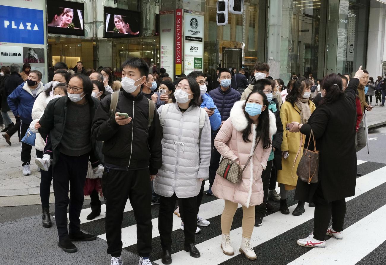 新型肺炎の感染拡大が懸念される中、マスク姿で東京・銀座を訪れた中国からの団体旅行客（共同）