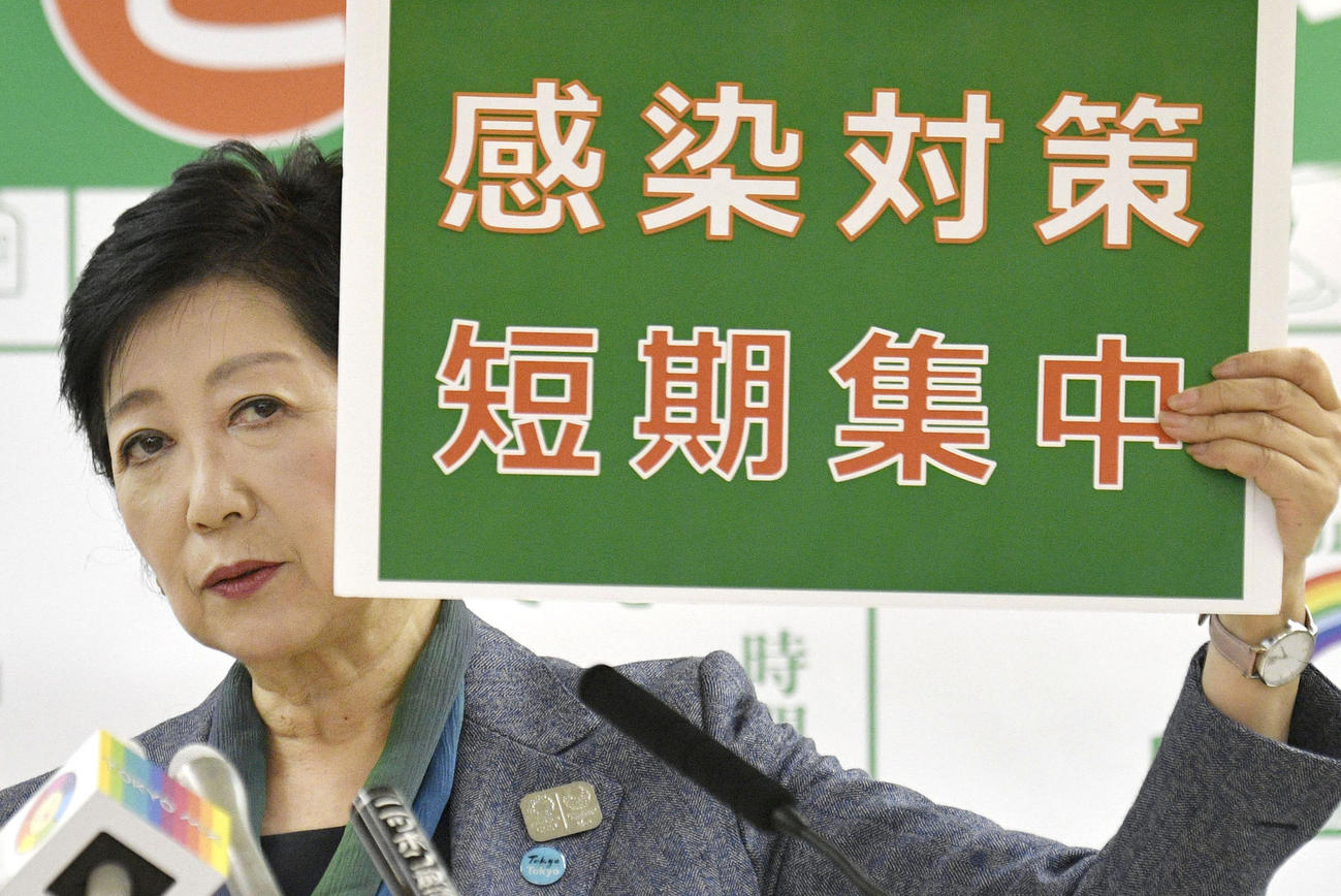 ボードを手に記者会見する東京都の小池百合子知事（共同）