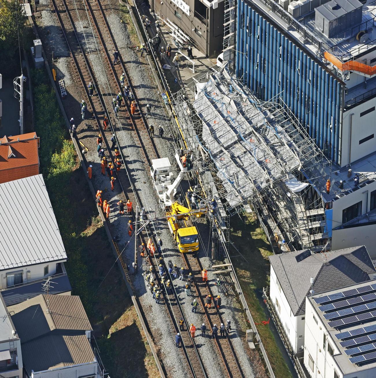東急東横線、自由が丘駅付近の線路脇で起きたビル建設現場の足場崩落事故で、復旧作業にあたる作業員ら（共同）