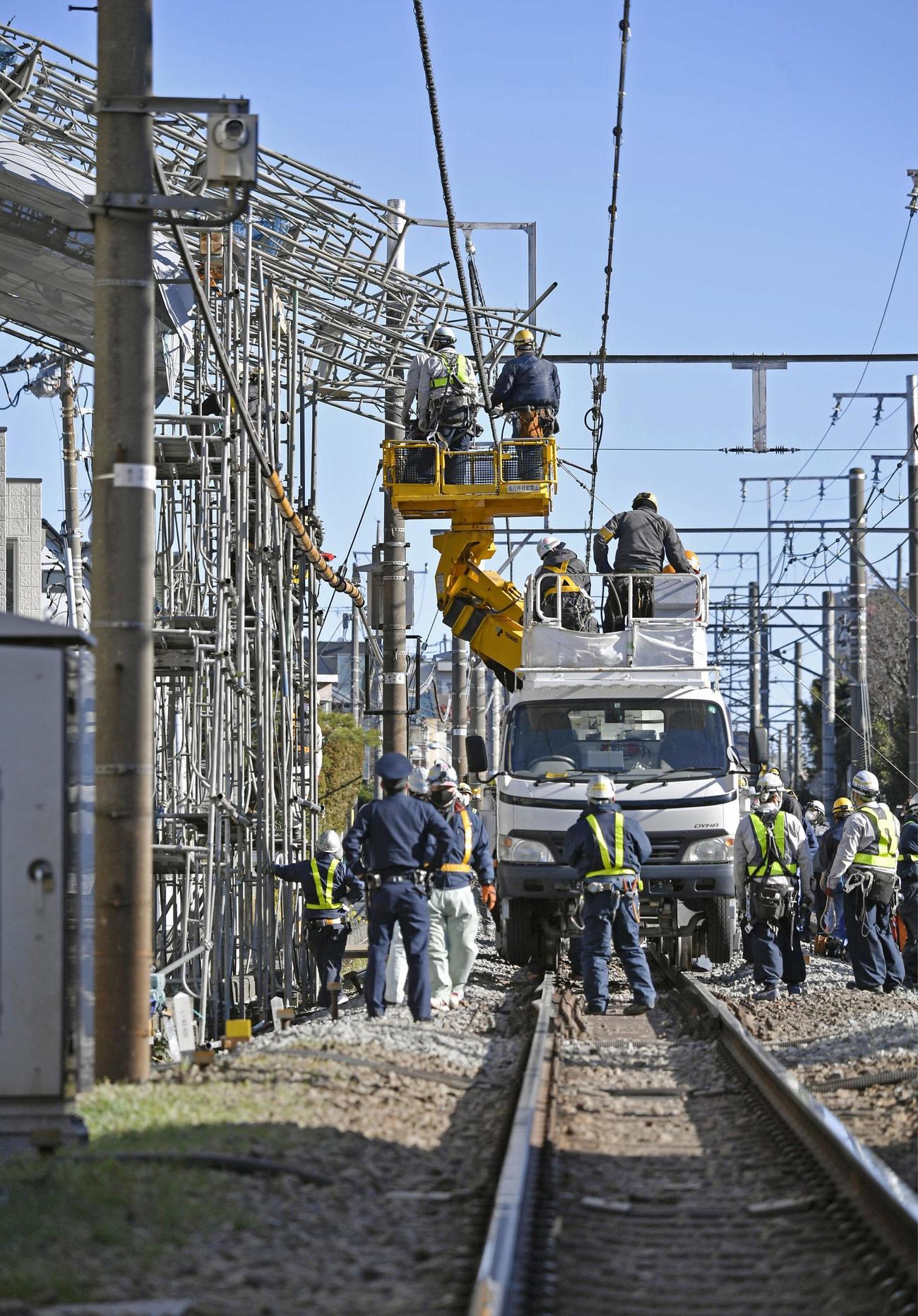東急東横線、自由が丘駅付近の線路脇で起きたビル建設現場の足場崩落事故で、復旧作業に当たる作業員ら（共同）