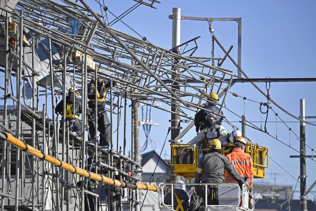 東急東横線、自由が丘駅付近の線路脇で起きたビル建設現場の足場崩落事故で、復旧作業に当たる作業員ら（共同）