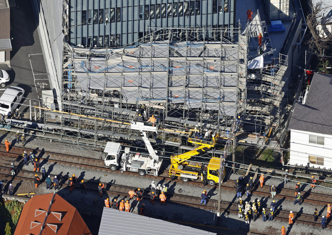 東急東横線、自由が丘駅付近の線路脇で起きたビル建設現場の足場崩落事故で、復旧作業にあたる作業員ら（共同）
